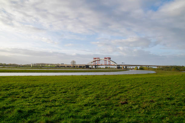 Landscape with the old arch bridge Lekbrug Vianen. \nTHis bridge is a former construction for traffic to pass the river de Lek over the highway A2 nearby Utrecht.