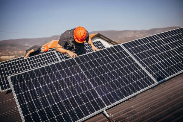 istock Solar panels installers on roof 1352647395