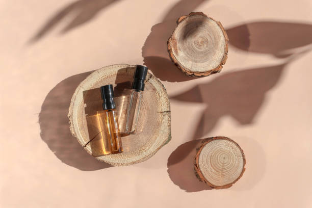 istock Two glass perfume testers with brown liquid on a woodcut with shadows. Top view 1352647506
