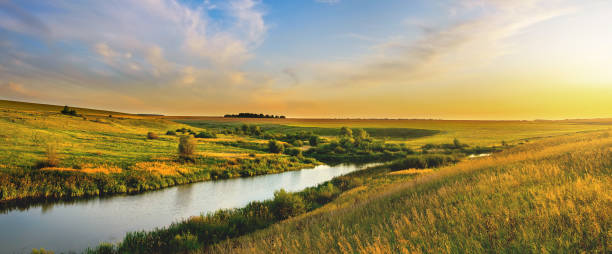 Beautiful summer landscape with colorful sunset sky over the calm river and hills summer evening scene prairie stock pictures, royalty-free photos & images