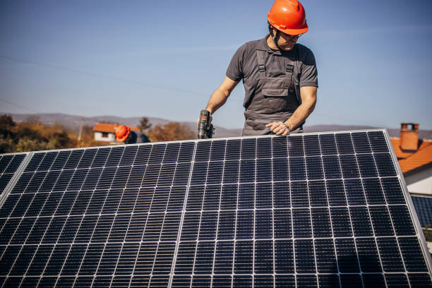 istock Solar panels installers on roof 1352647908