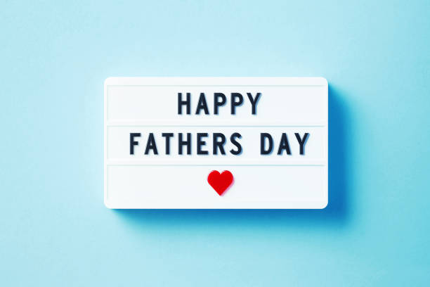 Happy Father's Day written white lightbox sitting on blue background. Horizontal composition with copy space.