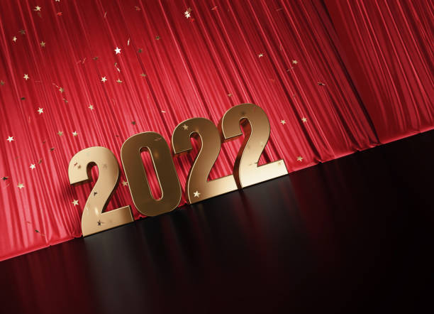 istock 2022 Concept - Gold Colored 2022 Sitting Before Red Curtain Under Star Shaped Confetti 1352652202