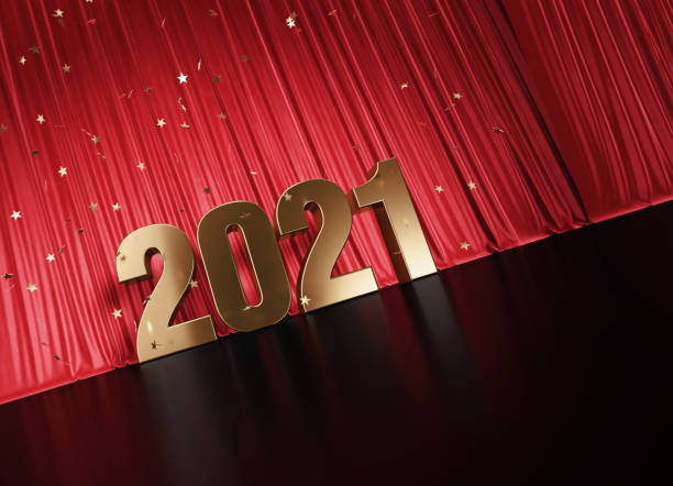 istock 2021 Concept - Gold Colored 2021 Sitting Before Red Curtain Under Star Shaped Confetti 1352652329
