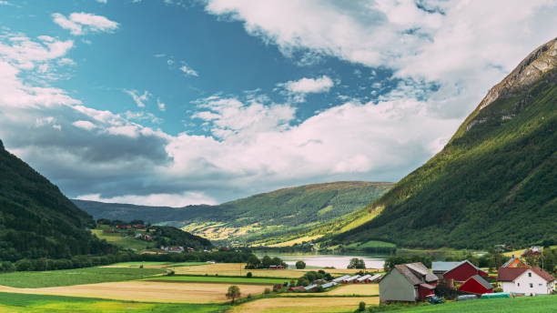 byrkjelo village, sogn og fjordane fylke, norwegen. wunderschöner himmel über der norwegischen ländlichen landschaft. bergheimsvatnet see im sommertag. landwirtschafts- und wettervorhersagekonzept. zeitraffer 4k - sogn og fjordane county stock-fotos und bilder