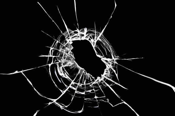 istock Hole in the window. Cracked broken black glass. Texture concept for design. 1352653874