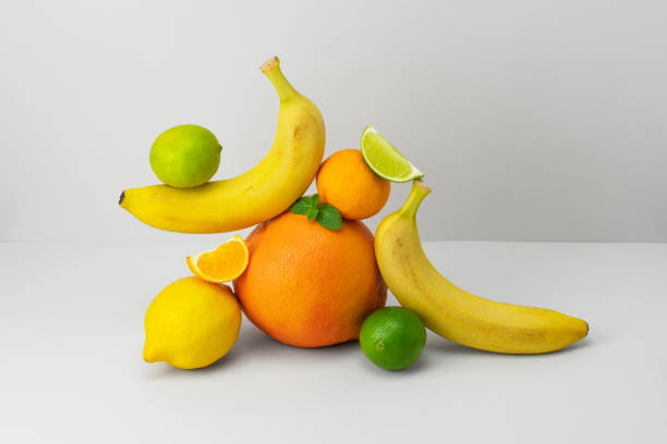 istock Fresh bananas, grapefruit, tangerine slice, lemon, lime and mint on grey background. Ripe yellow, orange and green fruits. Vitamin concept. Healthy food 1352654728