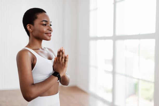 istock Black lady meditating keeping hands together in prayer pose 1352656195