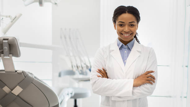 istock Stomatologic Services. Smiling Black Female Dentist Doctor Posing In Modern Clinic Interior 1352656708