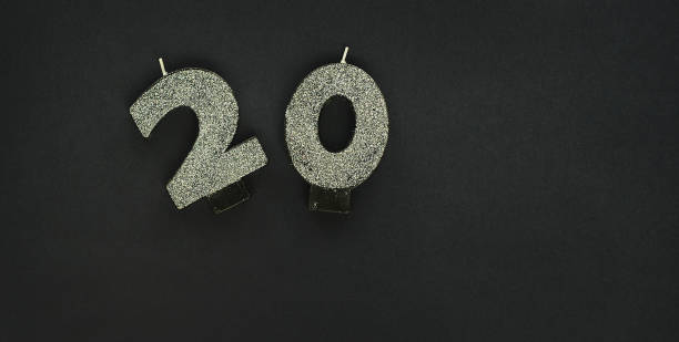 istock 20, silver candles on dark background with glitters. Festive colorful background. 1352659140