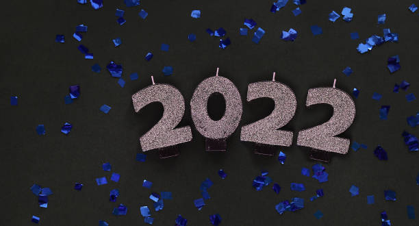 istock 2022 candles on dark background with glitters. Festive new year background. 1352659197