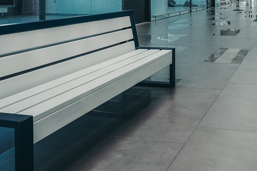 Photo of a white bench in a shopping center.