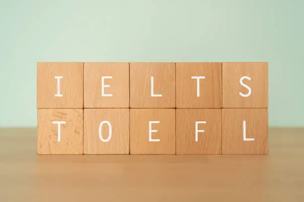 Wooden blocks with "IELTS TOEFL" text of concept.