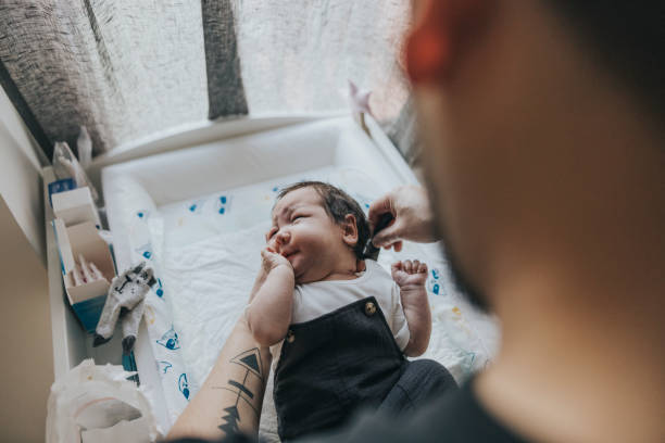 istock Father dressing up his baby 1352660705