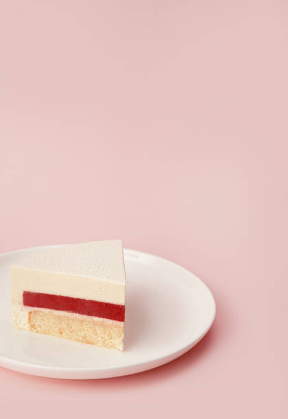 istock Delicious cherry mousse cake slice with the layers and texture displayed on pastel pink colored background. Close-up. Copy space. 1352662328