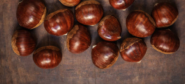 istock Chestnuts on on an old board with copy space. Autumn fall concept. Horse chestnuts top view