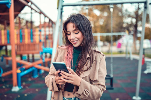 istock Female Beauty Exploring Social Media On Smartphone While Spending Day On Playground 1352663651