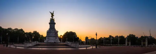 The historic Victoria Memorial at the end of The Mall overlooking St. James’s Park silhouetted at sunrise in the heart of London, UK.