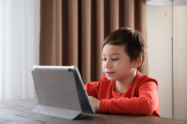 istock 4-5 years old child using digital tablet at home 1352666106