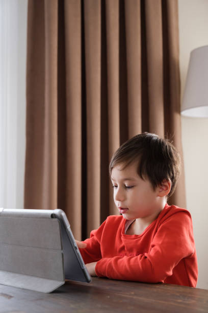 istock 4-5 years old child using digital tablet at home 1352666173