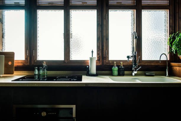istock Cozy interior of modern open kitchen, with kitchen accessories and cooking utensils. Sunlight coming through window 1352666197