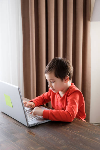 istock 4-5 years old child using laptop at home 1352666280