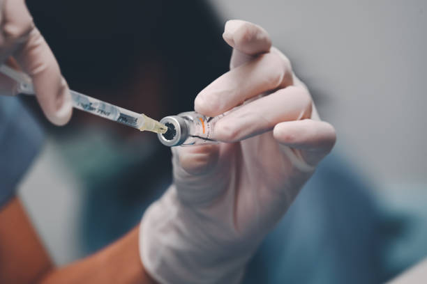 Doctor using a syringe pull COVID-19 Vaccine from vials bottles for can help stop pandemic, COVID-19 vaccines can help reduce the transmission of the new coronavirus from person to person