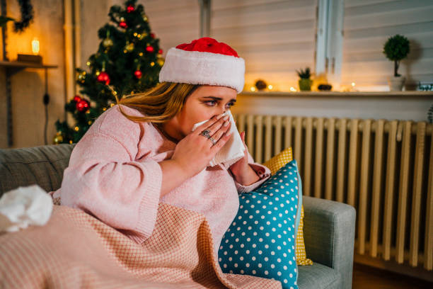 istock Sick woman covered with blanket wiping nose 1352666896