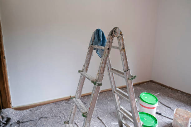 istock ladder, roller and paint roller, buckets with paint in an empty room ready to get paint. Painting walls, reconstruction works 1352676107
