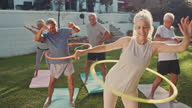 istock 4k video footage of a group of mature friends playing with hoola hoops together 1352679344