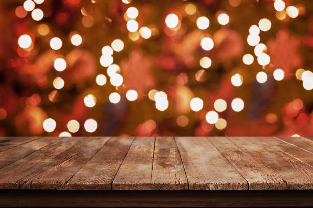 istock Empty wooden, rustic table with Christmas tree lights, bokeh in background 1352680664