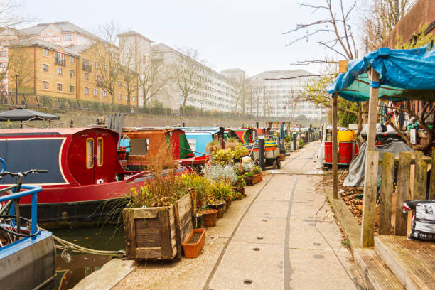 Old barges serving as homes on the Regent's Canal. London, United Kingdom; March 16th 2011: Old barges serving as homes on the Regent's Canal. small houseboats stock pictures, royalty-free photos & images