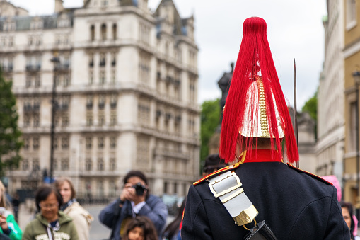 London, UK - 8th June 2017: Horse Guard soldier of the Household Cavalry Mounted Regiment who provide troops for The Queen's Life Guard. Tourists take photos outside of Horse Guards palace entrance.