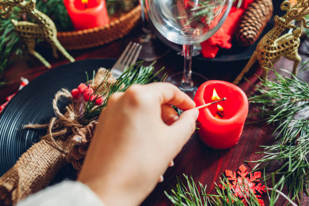 istock Festive Christmas dinner table setting for two decorated with fir branches, red candles, cones, ornaments. 1352683518