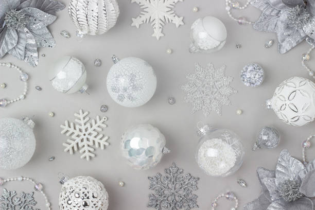 istock Holiday pattern made silver and white shiny christmas decorations on grey background. Happy Christmas, Xmas and New Year concept. Top view, Flat lay 1352685504