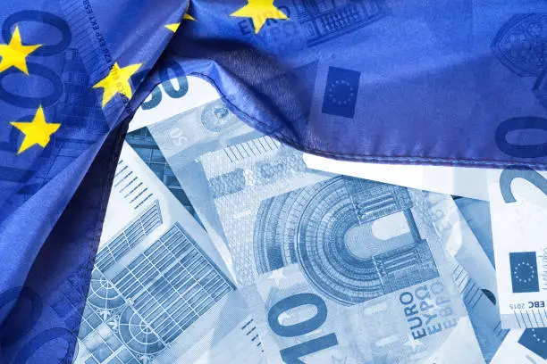 Photo of Flag of the European Union EU and euro banknotes