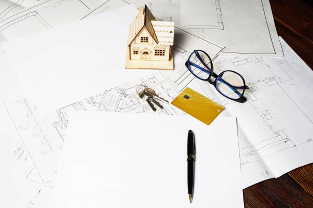 istock Model of a house and key ring, plan project and drawings on paper with copy space 1352687090