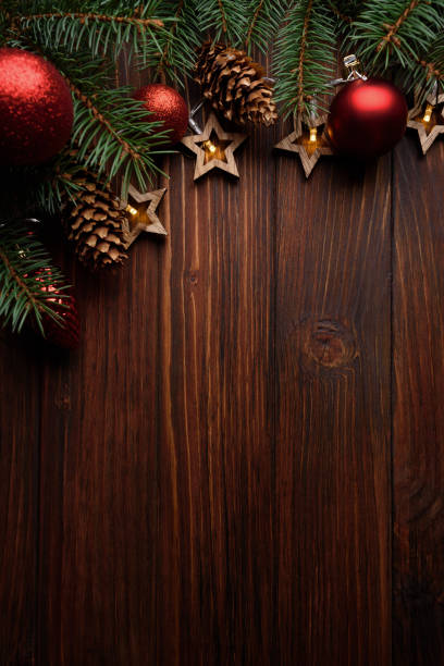 christmas background with fir branches, cones, red baubles and star shape lights on dark wooden board. top view. copy space. xmas decoration - table top shot fotos stockfoto's en -beelden