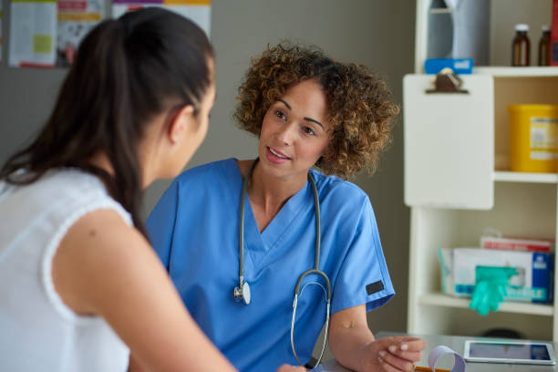 young woman chatting to a triage nurse stock photo