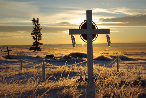 Crosses in a cemetery provide a tranquil and sacred scene as the early morning sun lights up the hoarfrost.