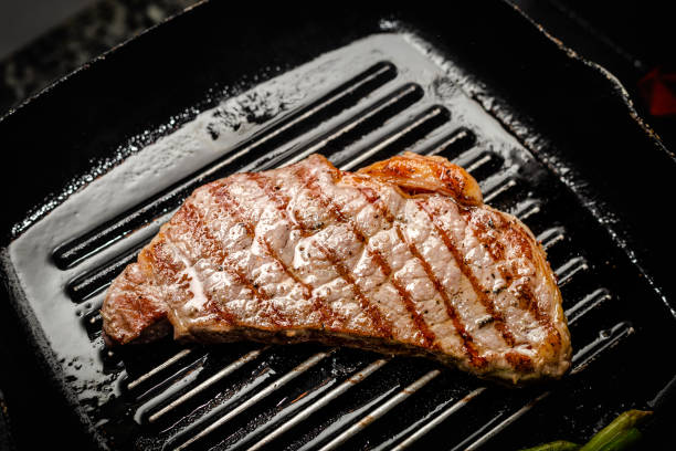 istock Close up wagyu beef striploin steak with pepper on dark pan 1352694023
