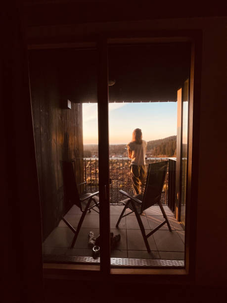 istock Young woman relaxes on balcony at sunrise 1352697298