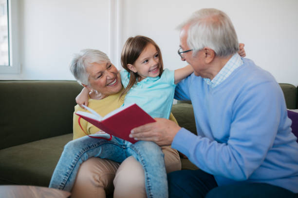 istock Seniors reading a book with child 1352698364