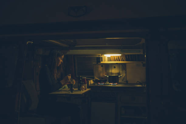 istock Young woman prepares meal inside motorhome 1352700503