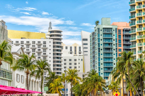 Miami South Beach Ocean Drive road street with famous retro art deco hotel colorful buildings cityscape with palm trees and blue sky on sunny day stock photo