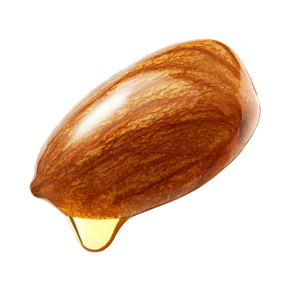 Almonds with oil drop isolated on white background