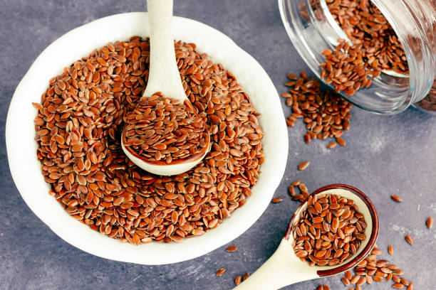 Healthy Flaxseeds / Linum Usitatissimum in a Bowl and Spoon Directly Above Photo stock photo