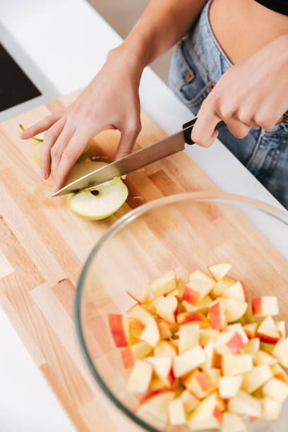 istock Cropped image of woman cutting apples 1352707605
