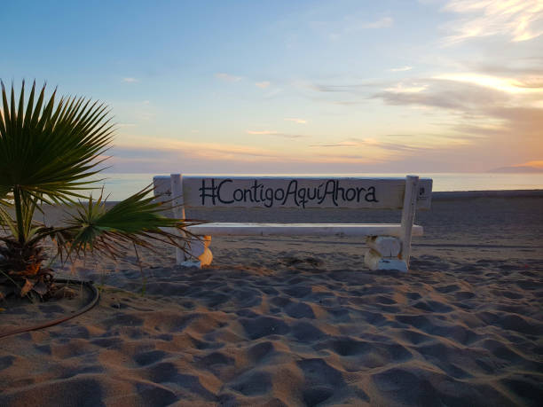 Torrox, Malaga-Spain; 10-23-2020, Lonely bench on the beach looking to the horizon, tranquility concept, Where it is written, `with you here and now`