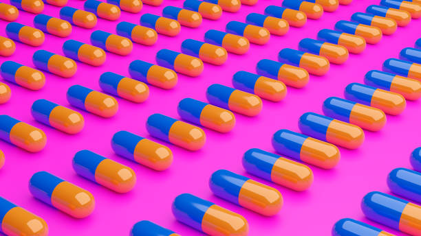 istock 3d illustration blue and yellow 3d pills on pink background 1352709501